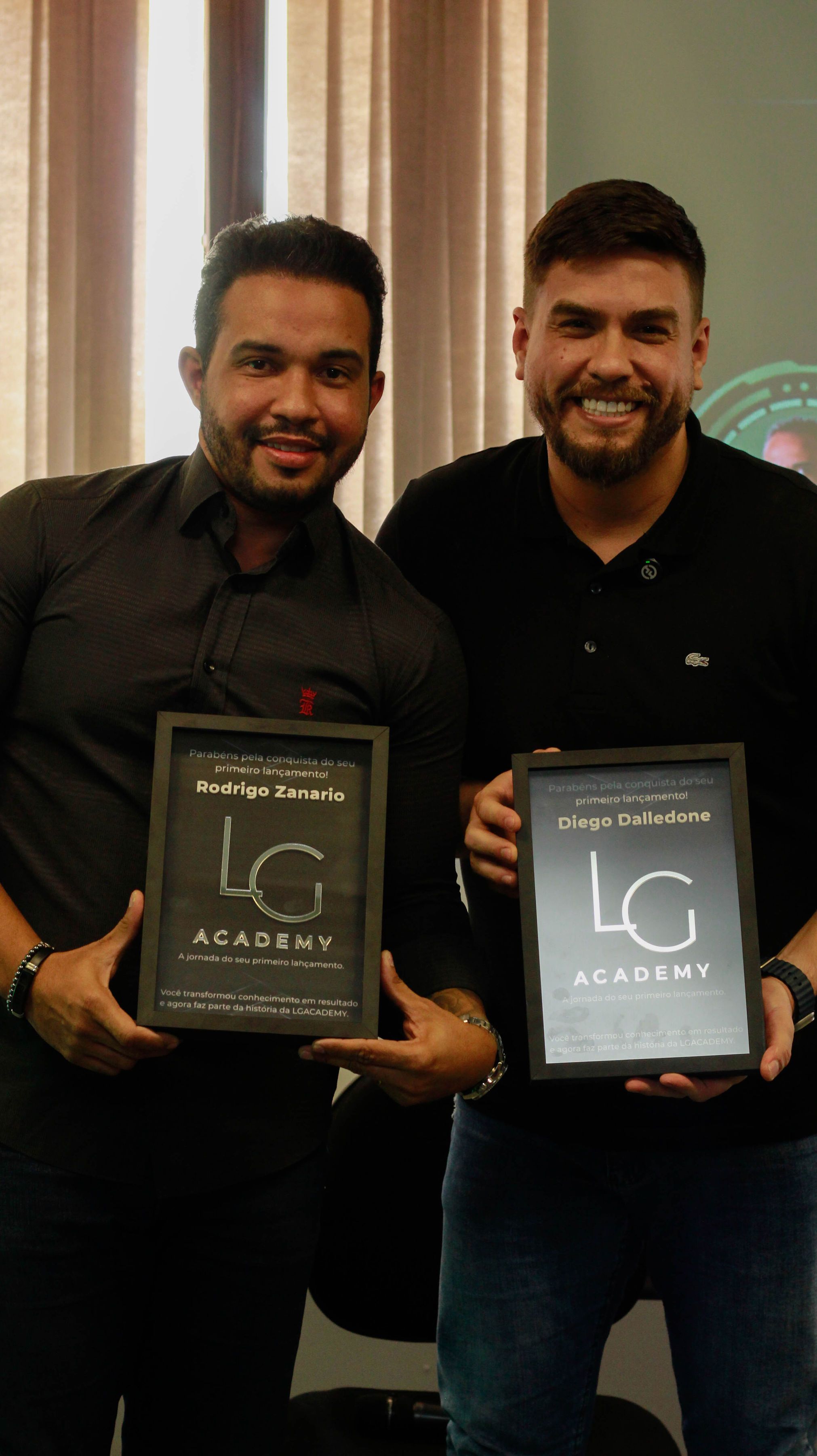 Rodrigo Zanário e Diego Dalledone com as placas do primeiro lançamento com a LG Academy, no palco do Café com Experts 2.